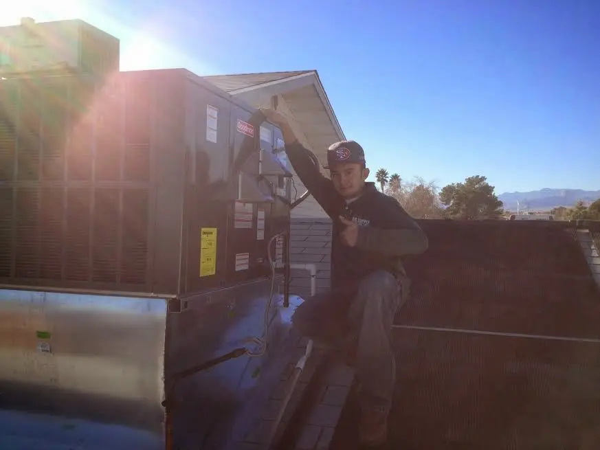 HVAC technician performing HVAC Inspection on a rooftop unit in Ellington